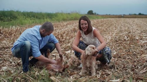 Happy dog owners petting their dogs