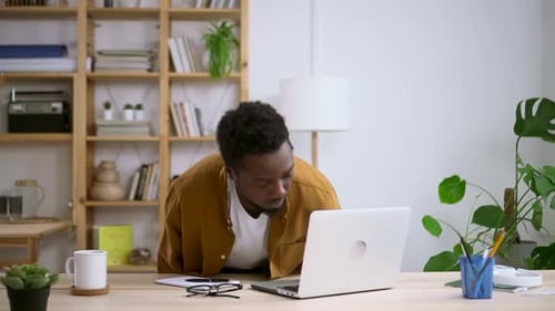 Man Working on Laptop Computer in Home Office