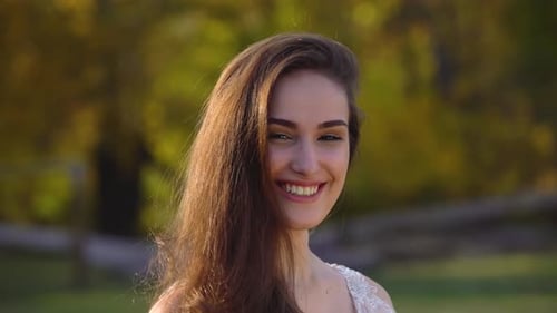 Portrait of Beautiful Brunette Bride Is Having Fun in Sunny Rays at Autumn Park