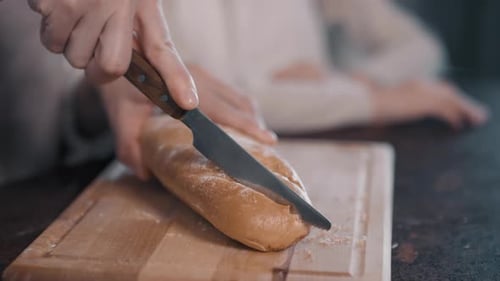 Slicing Fresh Bread Loaf in Kitchen Close Up