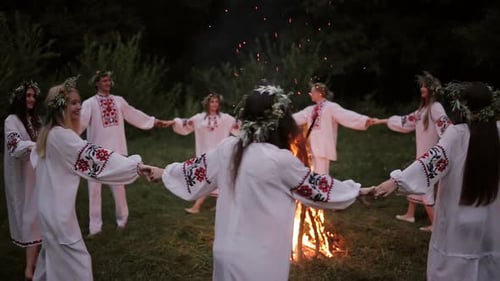 People Dancing Around Bonfire in Dark Forest
