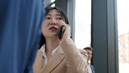Businesswoman Talking on Phone Inside Modern Building