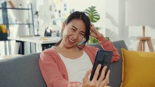 Smiling Woman Video Chats on Smartphone at Home