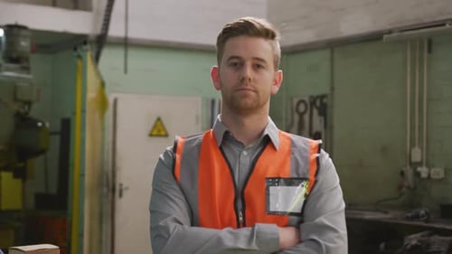 Caucasian male factory worker at a factory wearing a high vis vest