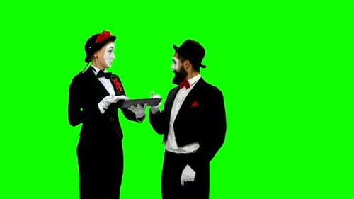Dos memes ven algo usando una tableta en pantalla verde