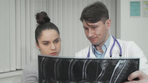 Doctor and Patient Reviewing Medical Scans in Office