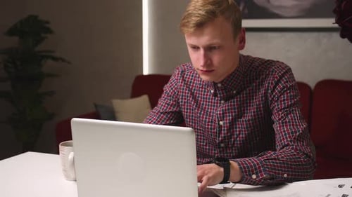 Young Adult Typing on Laptop at Home