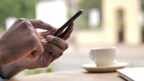 African Hand Typing Message on Smartphone
