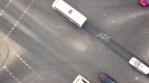 Top down aerial view of city traffic with cars moving on a street at roads intersection.