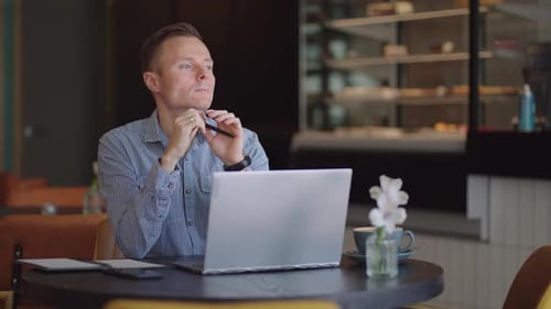 Thoughtful Serious Young Man Student Writer Sit at Home Office Desk with Laptop Thinking of