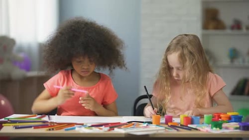 Two Young Children Enjoy Drawing at Home