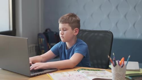 Boy Using Laptop at Desk
