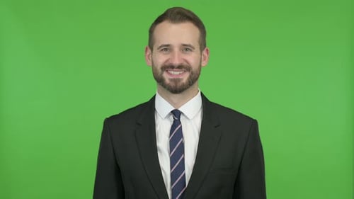 Cheerful Businessman Smiling at Camera Against Chroma Key