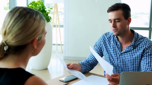 Business Colleagues Discuss Documents in Modern Office