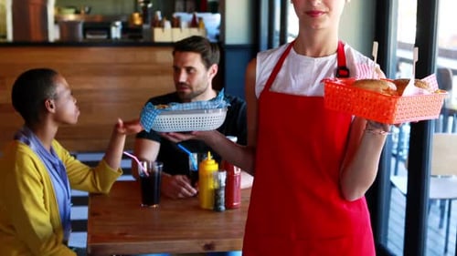 Waitress holding burger and french fries in tray
