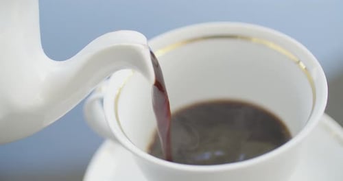Pouring Hot Tea into Teacup in Close-Up