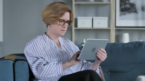 Woman Celebrates Success on Tablet Indoors