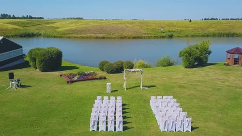 Wedding Venue with Arch and Chairs Near River Upper View