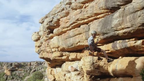 Mountaineer rappelling down the hill with the help of rope 4k
