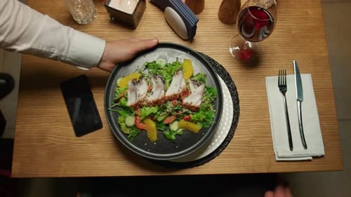 Waiter Hand Putting Food Plate on Fancy Restaurant Table