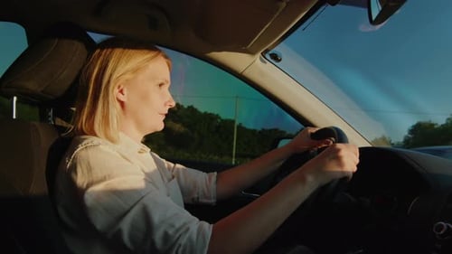 Woman Driver Behind the Wheel of a Car Drives on the Highway