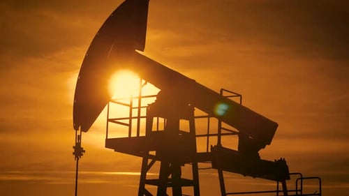 Silhouetted Oil Pump Pumping at Sunset