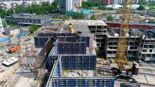 Un Drone quitte des ouvriers du bâtiment qui versent du ciment dans un coffrage bleu