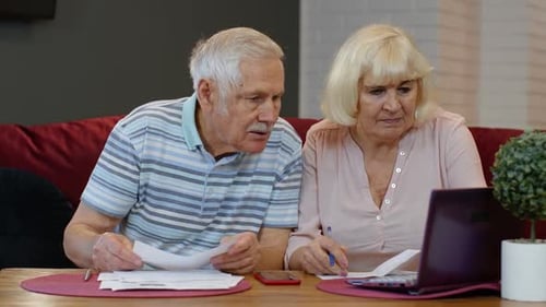 Senior Pensioner Couple Checking and Calculating Domestic Bills Bank Loan Payment Doing Paperwork
