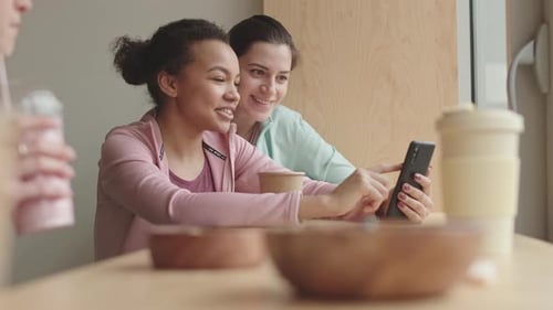 Female Friends Using Smartphone in Cafe