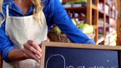 Smiling Woman in Grocery Store Holding Organic Sign