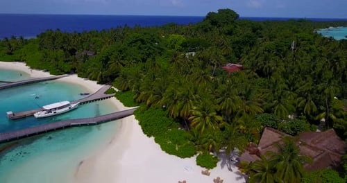 Daytime flying travel shot of a paradise sunny white sand beach and blue water background in colourf