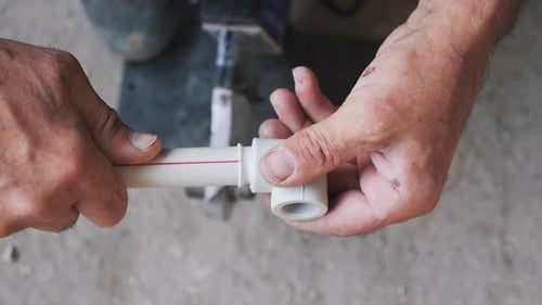 Plumber Welds Pipes with Welding Machine Close Up