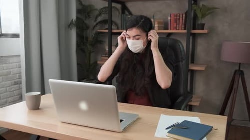 Confident Woman with Face Mask Wearing Headset. Call Center Agent Consult Business Client Online