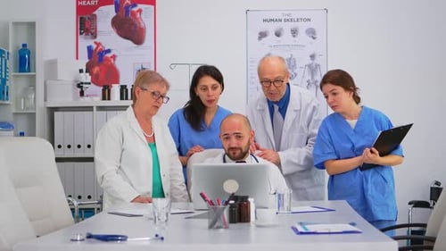 Medical Team Collaborating on Laptop in Hospital Office