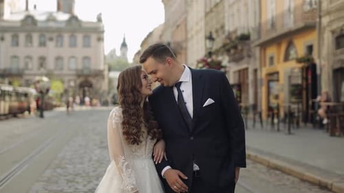Newlyweds Portrait Caucasian Groom Bride Walking Embracing Hugs on City Street Wedding Couple