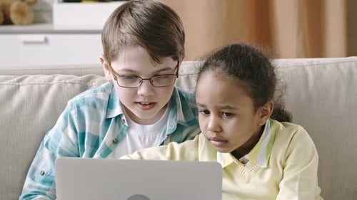 Kids Using Laptop Together on Couch at Home