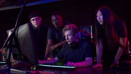 Concerned Team Watching Young Man Use Computer at Night
