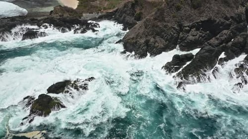 Ocean Waves Crashing Against Rocky Tropical Coastline