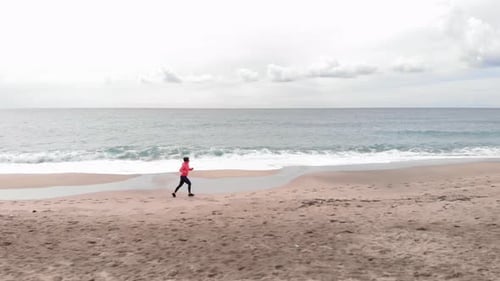Woman Runs on Beach for Health and Fitness