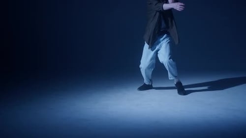 Young Blonde Guy Dancing Modern Choreography in Dark Studio Background