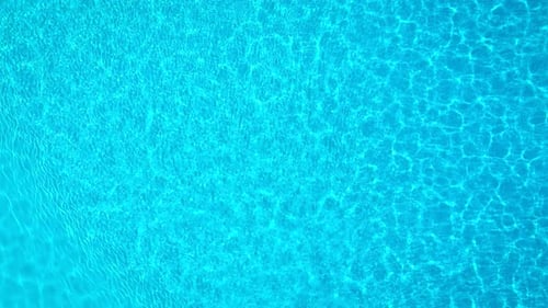 Blue Water in the Swimming Pool with Light Reflections