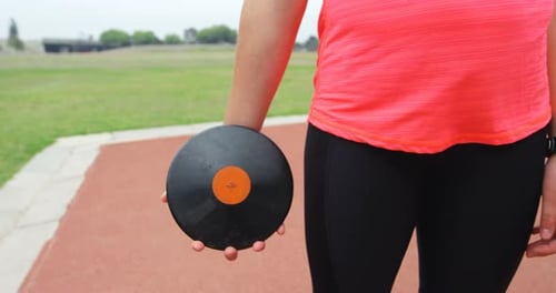 Woman Holding a Discus at a Track and Field