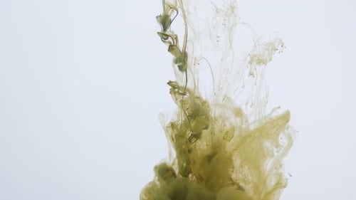 Green Paint Explodes and Sprays in the Water on a White Background