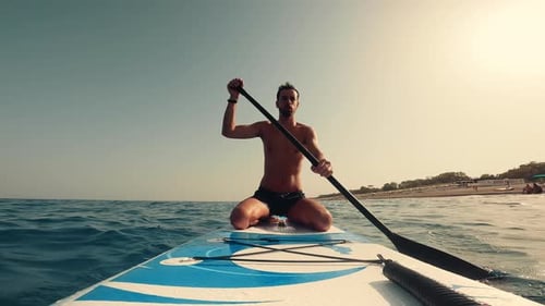 Man Paddleboarding on Ocean on Summer Day