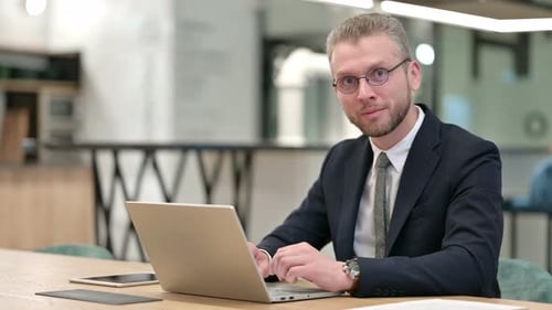 Thumbs Up By Positive Businessman Working in Office