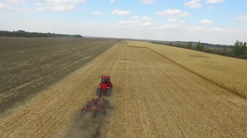 Red Tractor Cultivating Field on Rural Farm