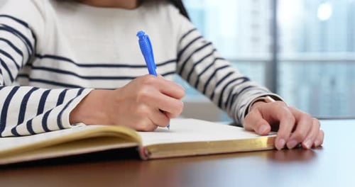 Writing in Notebook with Blue Pen Close Up