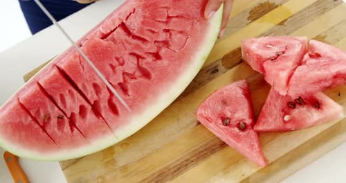 Mid-section of woman cutting fruits on chopping board against white background