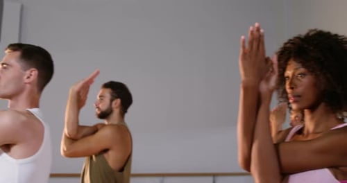 Group of people Practicing yoga in fitness studio