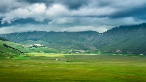 Sunset over valley in mountains at spring, Castelluccio, Italy